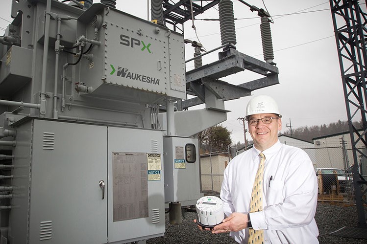 NRLP General Manager Ed Miller is holding an Advanced Metering Infrastructure (AMI) device.