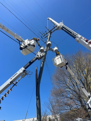 NRLP lineworkers in bucket trucks restore power after vehicle crashed into utility pole.