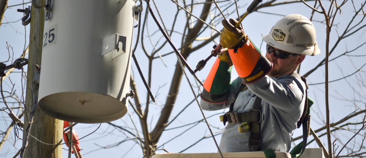 NRLP lineworker works in a bucket on a transformer to restore power.